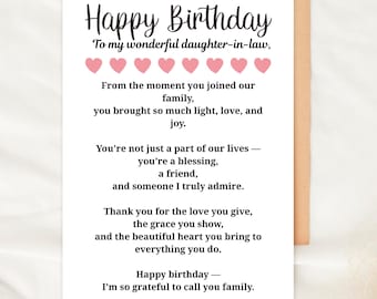May include: A birthday card with a kraft paper envelope. The white card has the text "Happy Birthday" in a script font, followed by a message to a daughter-in-law. Pink heart graphics are above the message.