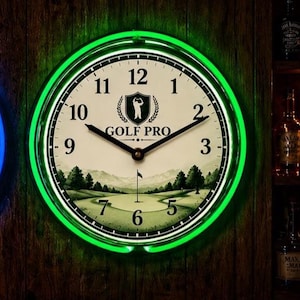 May include: A circular wall clock with a green neon light surround. The clock face is white with black numerals and hands. The words "GOLF PRO" are printed on the clock face, along with a golf course scene.