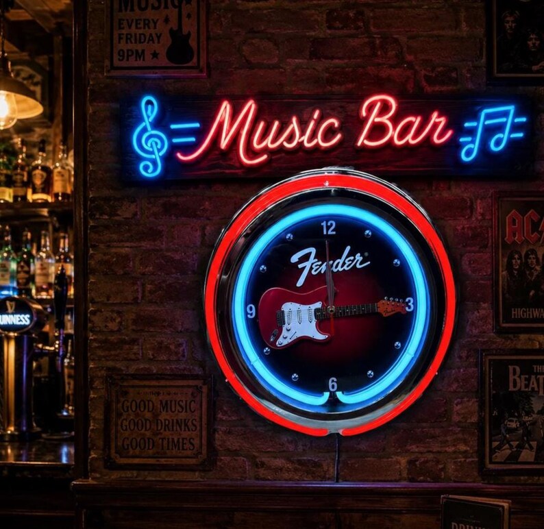 May include: A neon sign saying "Music Bar" in red and blue, above a clock with a Fender guitar design. The clock has a red and blue neon border. The background is a brick wall.