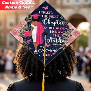 Könnte beinhalten: Eine dunkelblaue Abschlusskappe mit floralen und Schmetterlingsmotiven. Auf der Kappe steht der Text "I TRUST THE NEXT Chapter BECAUSE I KNOW THE Author" und der Name "Jasmine" mit dem Jahr "2026". Eine Figur in einem weißen Kleid und rosa Abschlusskleidung ist ebenfalls abgebildet.