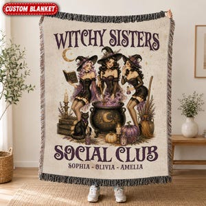 May include: A woven throw blanket featuring the text WITCHY SISTERS SOCIAL CLUB and the names SOPHIA, OLIVIA, AMELIA. The design depicts three witches in black outfits around a cauldron, a black cat, a broom, books, and pumpkins.