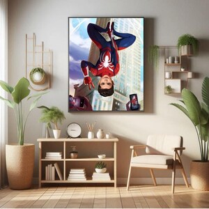 May include: A framed illustration of a superhero in a red and blue suit hanging upside down in front of a tall building. The superhero is holding a peace sign with one hand and is looking at the camera. Two mobile phones are being held up to take a picture of the superhero.