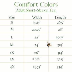Op de afbeelding: Een Comfort Colors tabel voor een volwassen T-shirt met korte mouwen, maten S tot 4X. Breedtes vari&euml;rend van 46,36 cm tot 75,57 cm, lengtes van 67,31 cm tot 85,09 cm. Een kleine bij is aanwezig.