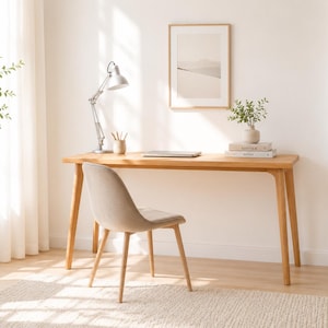 Peut inclure: Un bureau en bois clair doté de quatre pieds fuselés, accompagné d'une chaise rembourrée beige avec un dossier incurvé. La surface du bureau supporte une lampe de bureau argentée réglable, un pot à crayons, un ordinateur et des livres.