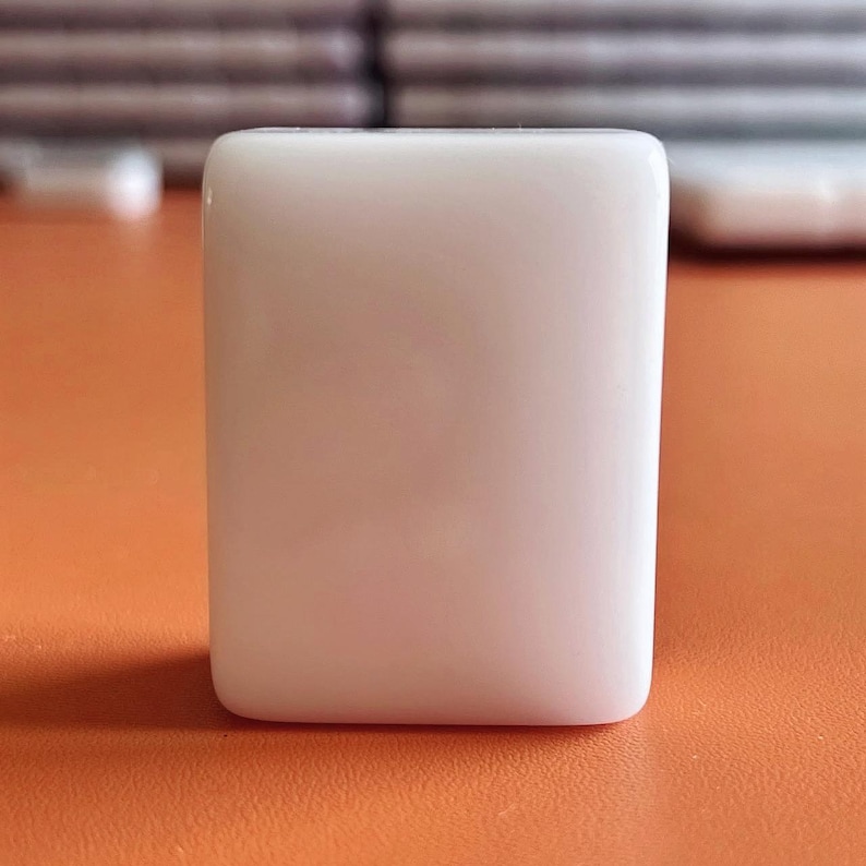 May include: A white ceramic tile with a smooth, glossy finish.