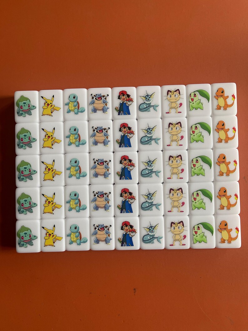 May include: A set of 36 white dominoes with colorful Pokemon characters printed on each side. The characters include Pikachu, Bulbasaur, Squirtle, Charmander, and more.