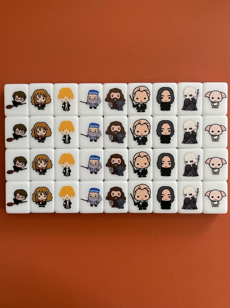 May include: Set of 36 white ceramic tiles with Harry Potter characters. Each tile features a different character from the Harry Potter series, including Harry Potter, Ron Weasley, Hermione Granger, Draco Malfoy, and more. The tiles are perfect for playing games or decorating a Harry Potter themed room.