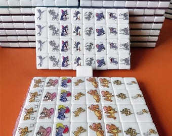 May include: A set of white dominoes with cartoon images of Tom and Jerry. The dominoes are arranged in a grid pattern with the Tom and Jerry images on each domino.