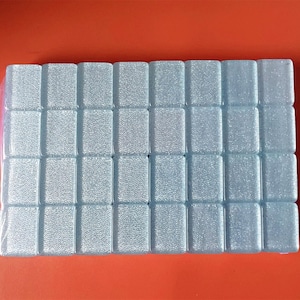 May include: A sheet of light blue square tiles with a textured surface.