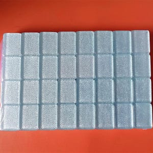 Puede incluir: Una l&aacute;mina de azulejos cuadrados de color azul claro con una superficie texturizada.