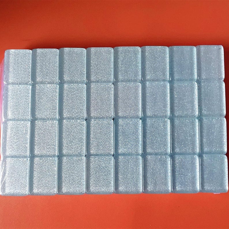 Puede incluir: Una l&aacute;mina de azulejos cuadrados de color azul claro con una superficie texturizada.