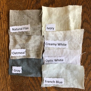 May include: Six fabric swatches in different shades of white, gray, and blue. The swatches are labeled with the following names: Natural Flax, Ivory, Creamy White, Optic White, Gray, and French Blue.