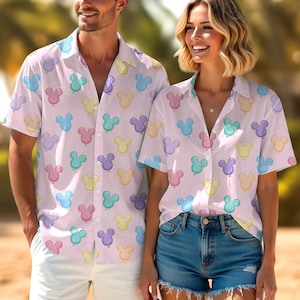 May include: Light pink button-down shirt with a repeating pattern of colorful cartoon mouse heads. The shirt has short sleeves and a classic collar. The shirt is worn by a person.