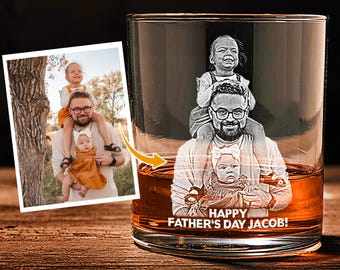 May include: A personalized whiskey glass with a photo of a man and two children etched on the front. The glass is filled with amber liquid and features the text "HAPPY FATHER'S DAY JACOB!"