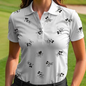 Puede incluir: Polo blanco con un patr&oacute;n repetido de ilustraciones de Mickey Mouse en blanco y negro. La camisa tiene cuello, mangas cortas y tapeta abotonada. El dise&ntilde;o es una versi&oacute;n l&uacute;dica y caprichosa de un polo cl&aacute;sico.