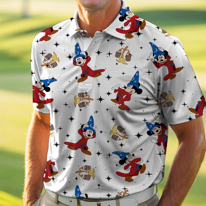Puede incluir: Polo blanco con un estampado repetido de Mickey Mouse con un disfraz de mago, estrellas y escobas. La camisa de manga corta tiene cuello y est&aacute; hecha de un material ligero. El dise&ntilde;o incluye a Mickey con un sombrero de mago azul y una t&uacute;nica roja.