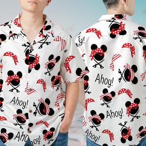 May include: White button-down shirt with a repeating pattern of Mickey Mouse wearing a pirate eye patch and bandana. The shirt has the text "Ahoy!" printed on it.