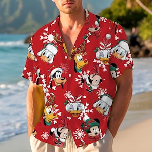 May include: Red button-down shirt featuring a festive pattern of Disney characters in holiday attire, including Mickey Mouse, Donald Duck, and Goofy, with snowflakes. The shirt has short sleeves and a classic collar, perfect for a casual holiday look.