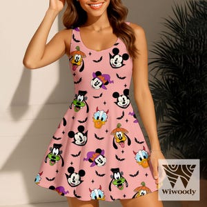 May include: Pink sleeveless dress featuring a pattern of cartoon characters in Halloween costumes, including Mickey Mouse, Donald Duck, and Goofy. The dress has a flared skirt and is decorated with bats and stars.