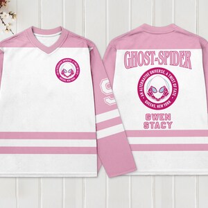 May include: Pink and white hockey jersey featuring the Ghost-Spider logo on the front and back. The jersey has pink sleeves with white stripes and the number 99. The back of the jersey reads "Ghost-Spider" and "Gwen Stacy".
