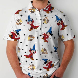 Puede incluir: Polo blanco con un estampado repetido de Mickey Mouse como hechicero, barriles y estrellas. Mickey lleva t&uacute;nicas rojas y un sombrero de mago azul. La camisa tiene cuello abotonado y mangas cortas.