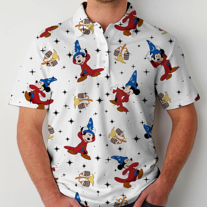 Puede incluir: Polo blanco con un estampado repetido de Mickey Mouse como hechicero, barriles y estrellas. Mickey lleva t&uacute;nicas rojas y un sombrero de mago azul. La camisa tiene cuello abotonado y mangas cortas.
