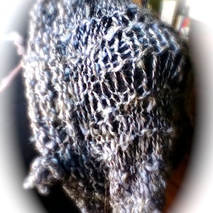 May include: A close-up of a black and white knitted fabric with a textured, fuzzy surface.