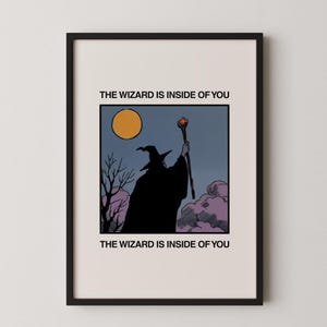 Könnte beinhalten: Gerahmter Kunstdruck mit einer Zauberer-Silhouette, die einen Stab unter einem Vollmond hält. Das Bild ist vor einem dunkelblauen Himmel mit lila Wolken und kahlen Bäumen platziert. Der Text "THE WIZARD IS INSIDE OF YOU" ist oberhalb und unterhalb des Bildes gedruckt.
