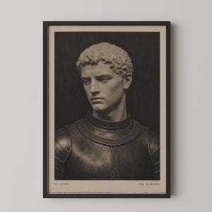 May include: A framed wall art print featuring a monochromatic portrait of a sculpted bust of a person with curly hair wearing metal armor. The text ST. VICTOR is printed in the bottom left corner and ELIA MARCHETTI in the bottom right corner.