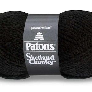 May include: A skein of black Patons Shetland Chunky yarn. The label reads "Yarninspirations", "Patons", "Shetland Chunky", and features a honeycomb design.