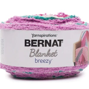 May include: A skein of Bernat Blanket Breezy yarn in a pink, white, and teal color combination. The yarn is soft and fluffy, and it is perfect for making blankets, scarves, and other cozy projects.