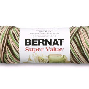 May include: A ball of Bernat Super Value yarn in shades of green, brown, and cream. The label states the yarn is 142 g. The yarn is made from 100% acrylic and is suitable for knitting and crochet projects. The ball of yarn has a length of approximately 231 m.