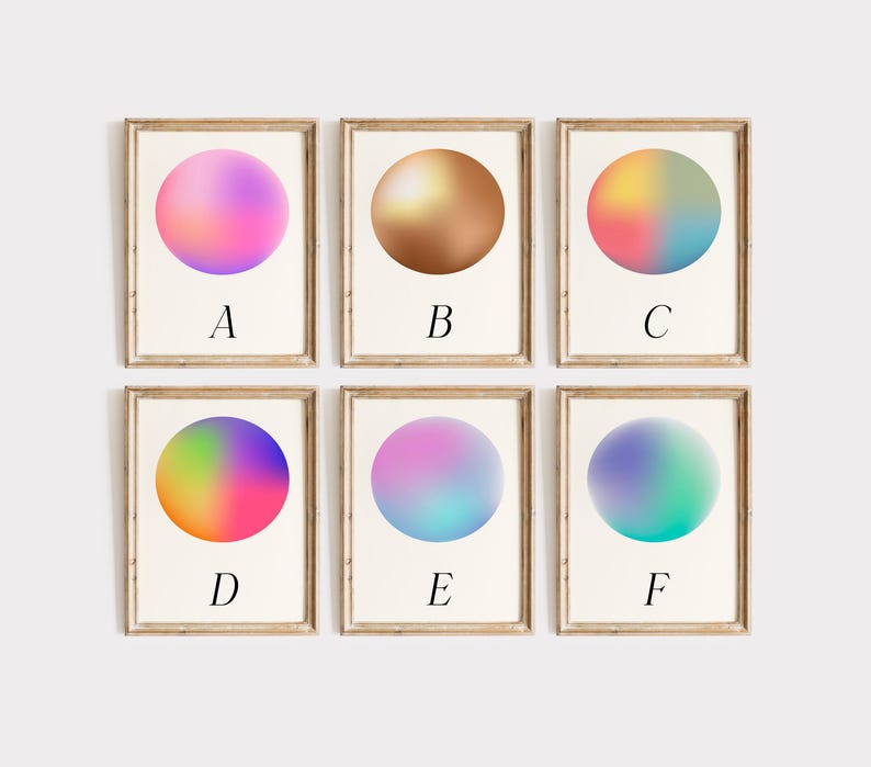 May include: Six framed art prints with colourful, gradient orb designs. Each print features a different colour scheme, including pink, gold, and blue. The letters A through F are printed below each orb. The frames are a light brown colour.