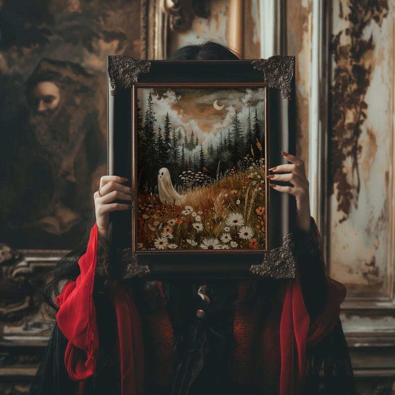 May include: A woman in a red and black dress holds a framed painting in front of her face. The painting depicts a forest scene with a white ghost figure in the foreground and a crescent moon in the sky.