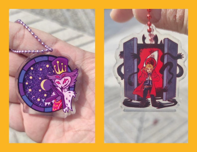 May include: Two acrylic keychains. One features a purple and white cartoon character with a crown, set against a starry night background. The other depicts a character in a red coat in front of a red portal.