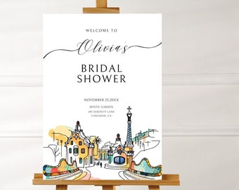 May include: A white bridal shower sign with a black calligraphy font that says "Welcome to Olivia's Bridal Shower". The sign also includes the date, location, and a colorful illustration of a cityscape.