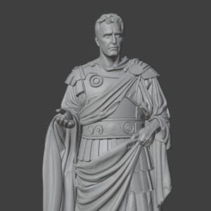 May include: A gray statue of a Roman figure, likely a Caesar, in classical attire. The statue features detailed armor, draped fabric, and sandals. The figure is standing on a textured base, with a serious expression.