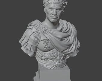 May include: A monochromatic gray bust of a Roman leader wearing a laurel wreath and detailed armor with a draped cloak. The sculpture features a stern facial expression and is mounted on a square, tiered pedestal base, capturing the likeness of a historical figure.