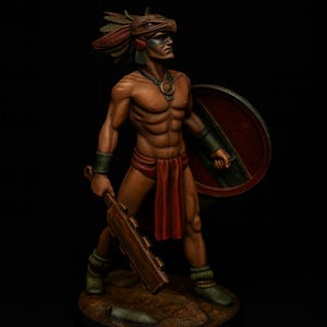 Puede incluir: Figura detallada de un guerrero, probablemente azteca o maya, con un tocado, escudo y garrote. La figura está pintada en tonos tierra con acentos rojos y verdes. El guerrero está de pie sobre una pequeña base oscura.