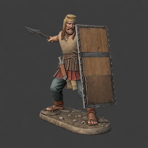 Op de afbeelding: Gedetailleerd beeldje van een krijger in oude kledij, met een gebogen mes en een houten schild. De figuur draagt een helm, tuniek en gelaagde rok, met een zwaard in de taille. De basis is een steenachtig platform.