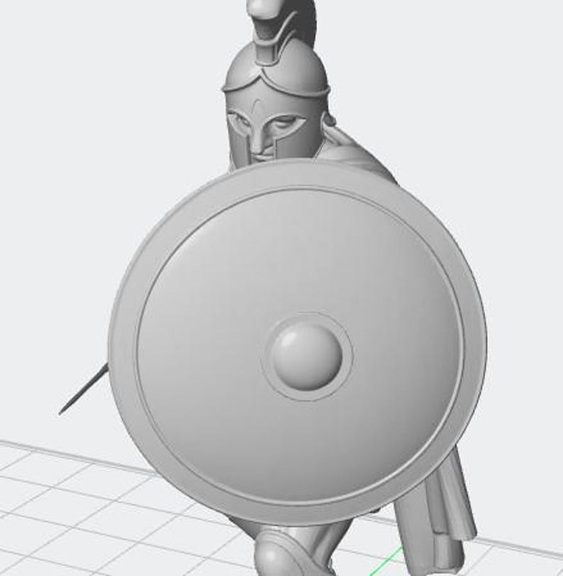 K&ouml;nnte beinhalten: Graue Figur eines spartanischen Kriegers, der einen runden Schild und einen Speer h&auml;lt. Der Krieger tr&auml;gt einen Helm und eine R&uuml;stung. Die Figur ist vor einem schlichten Hintergrund platziert.