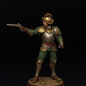May include: A miniature figure of a soldier in green and gold armour, holding a pistol and a sword. The figure stands on a small, round base with a brown rim. The soldier wears a helmet and has a determined expression.