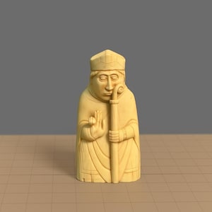 Puede incluir: Una pieza de ajedrez tallada, de color crema, que representa a un obispo. La figura lleva un sombrero y sostiene un báculo. La mano derecha del obispo está levantada en un gesto de bendición. La pieza está sobre un fondo neutro.