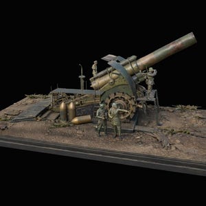May include: A detailed model of a large artillery cannon, painted in shades of green and brown, with miniature figures of soldiers. The cannon sits on a rectangular base with a dirt and debris landscape.