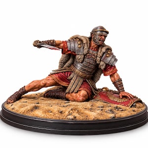 May include: A detailed figurine of a Roman soldier in a kneeling position, wearing metallic armor, a red tunic, and a fur-lined cloak. The soldier holds a dagger in one hand and rests the other on a red shield, set on a sandy base.