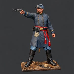 Könnte beinhalten: Detaillierte Figur eines Soldaten in blauer Uniform, der eine Pistole hält. Die Figur trägt einen Hut, einen roten Gürtel und schwarze Stiefel. Die Miniatur steht auf einer kleinen, strukturierten Basis mit dunklem Hintergrund.