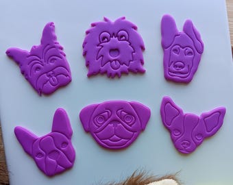 Puede incluir: Seis cortadores de galletas de silicona púrpura en forma de razas de perros, incluyendo un pug, un chihuahua, un bulldog francés, un yorkie, un pastor alemán y un doodle.