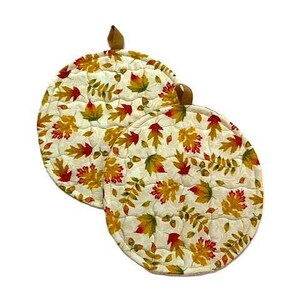May include: Two round quilted pot holders featuring a cream-colored background with a repeating pattern of autumn leaves in shades of red, orange, yellow, and green. Each pot holder includes a small brown fabric loop at the top for hanging.