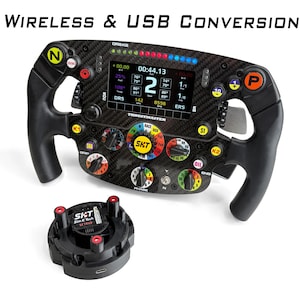 May include: A carbon fiber racing steering wheel with a central digital display showing telemetry data, multiple colorful buttons, rotary dials, and the text "WIRELESS & USB CONVERSION" above it, accompanied by a separate black circular base unit.