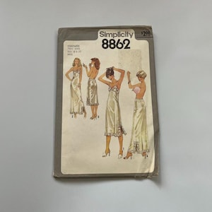 May include: Vintage Simplicity pattern 8862, featuring illustrations of elegant satin slip dresses. The pattern envelope is aged, with the Simplicity logo and the number 8862 prominently displayed. The envelope contains two sizes, 18 and 20.